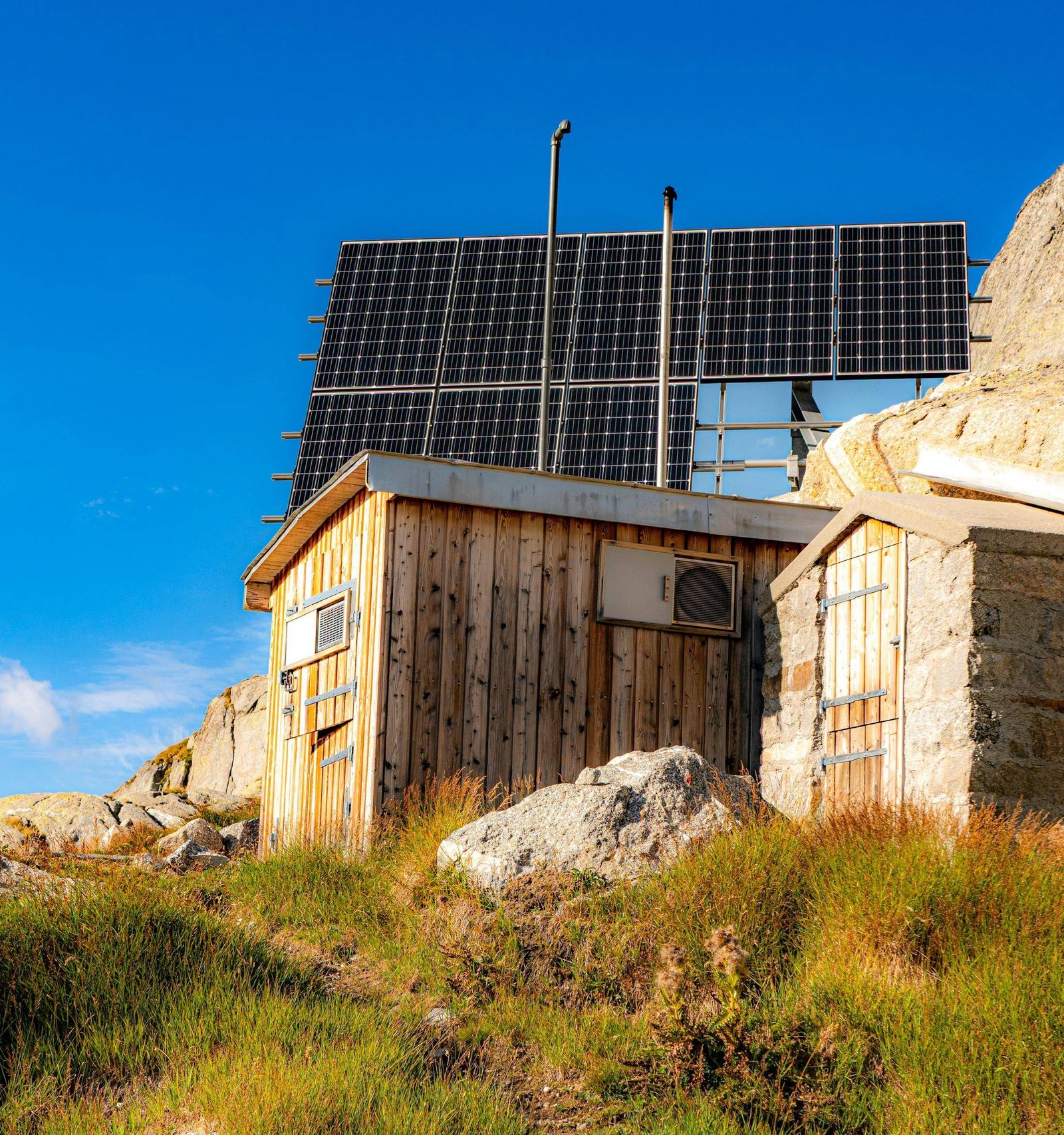 Cabană montană cu panouri solare, sub cerul albastru
