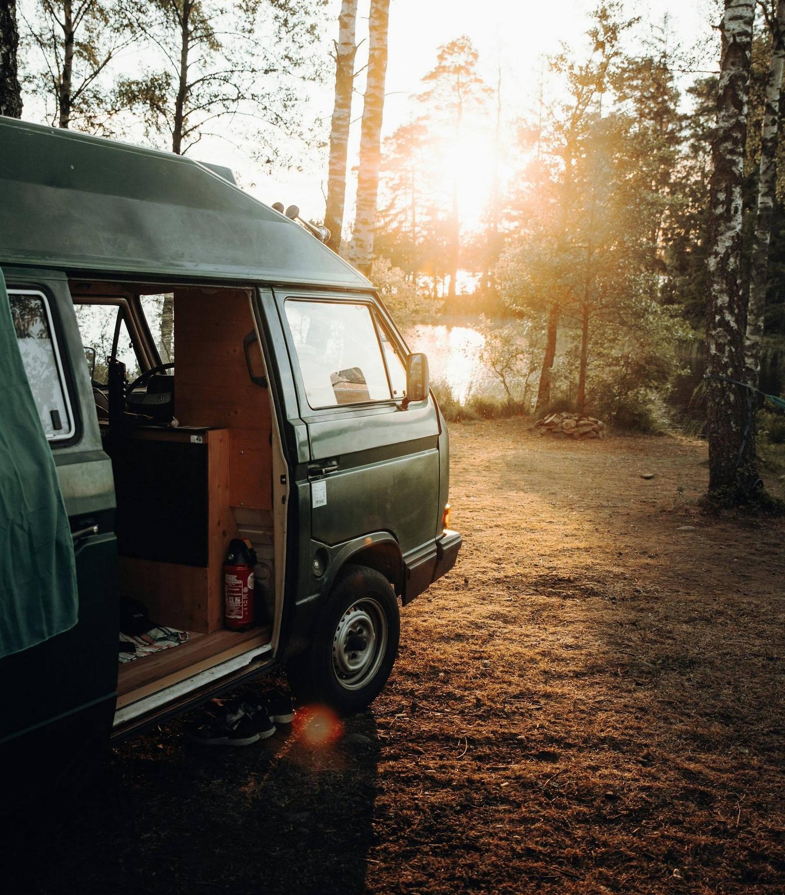 Dubă camper parcată în pădure la apus